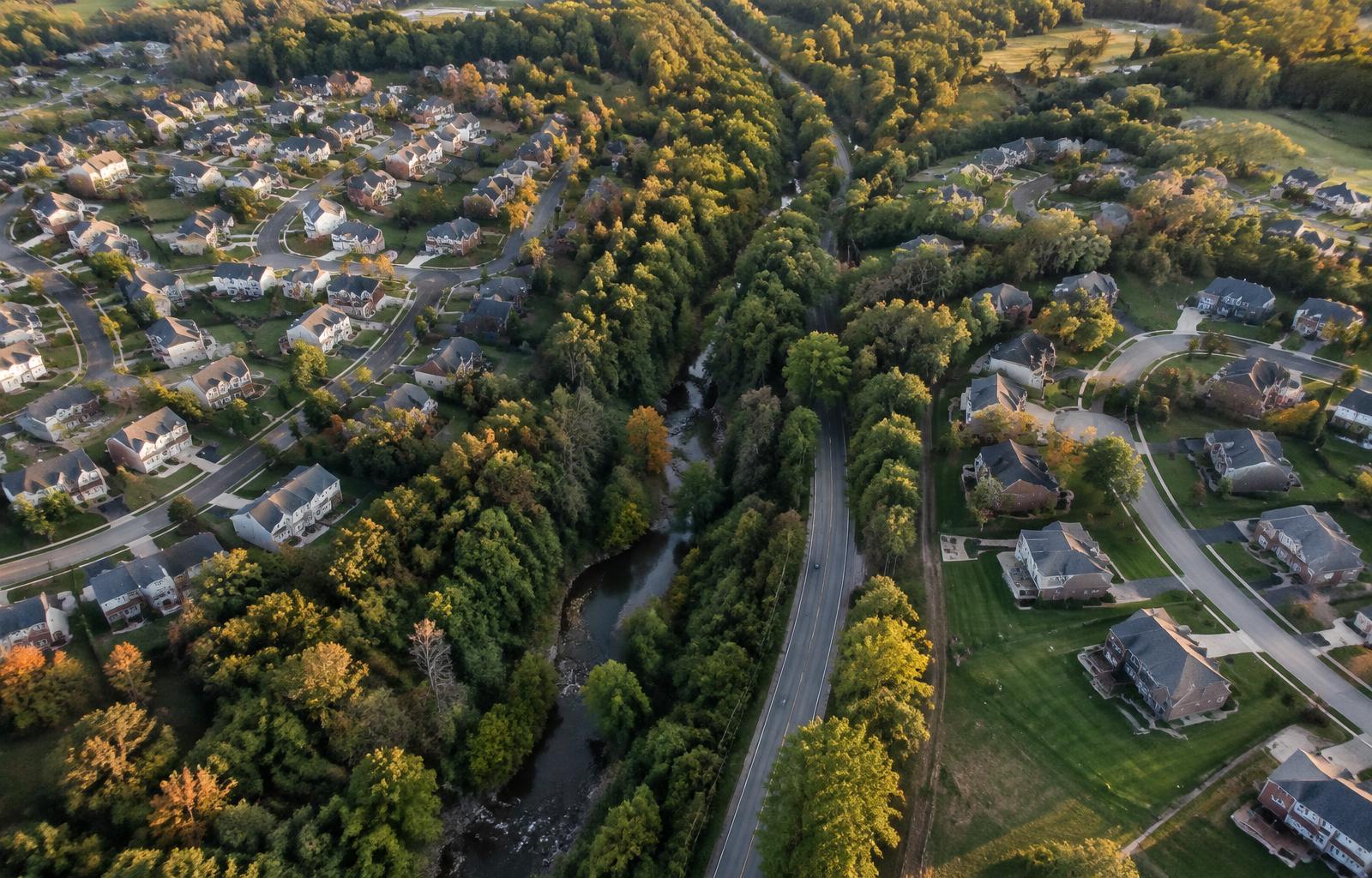 Representative aerial photograph of two suburban neighborhoods separated by a wooded creek corridor